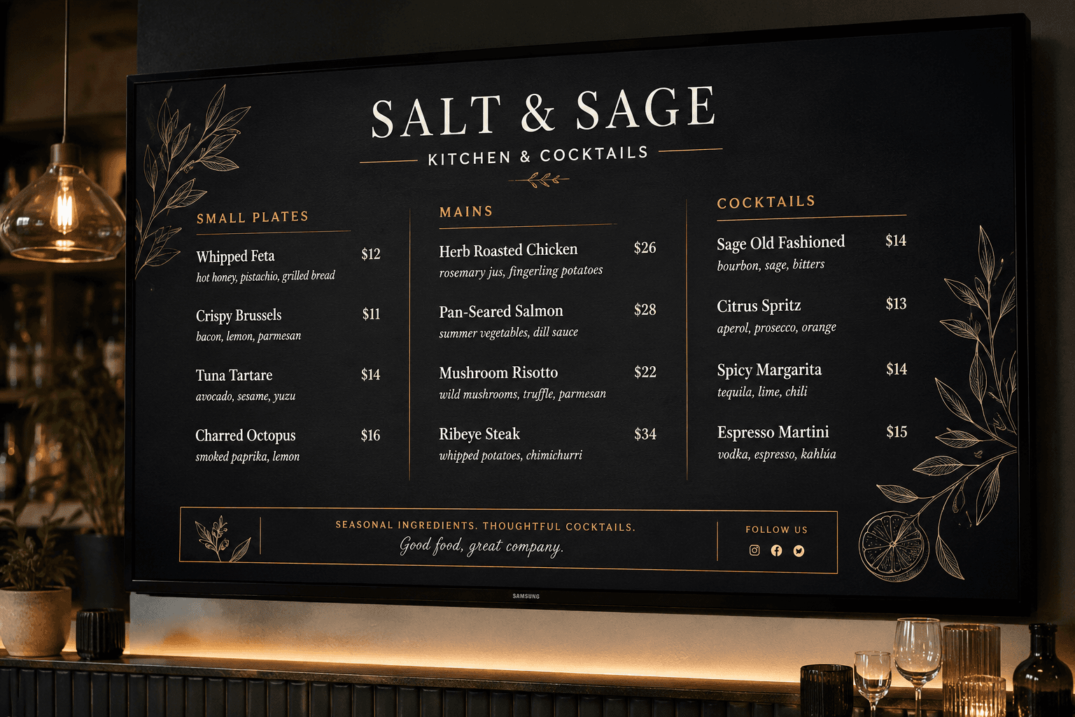 A TV mounted in a bar showing the Salt & Sage restaurant's menu design, with elegant serif type and gold botanical illustrations on a black background